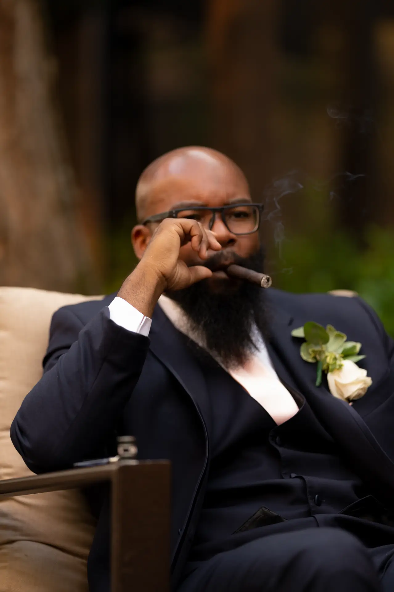 Groom wipes away tears while seated in a leather chair