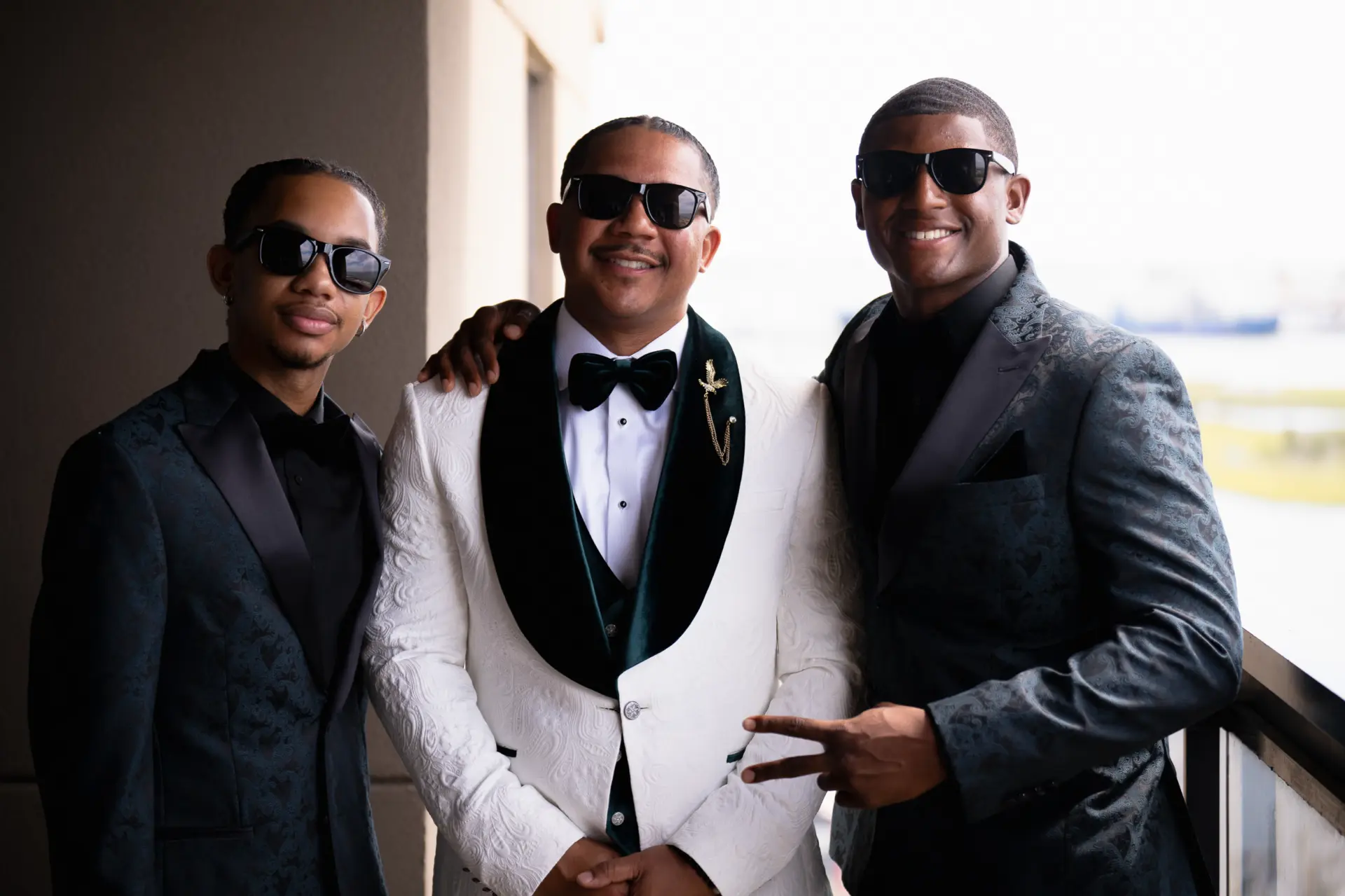 Groom in a white tuxedo jacket with his groomsmen in sunglasses