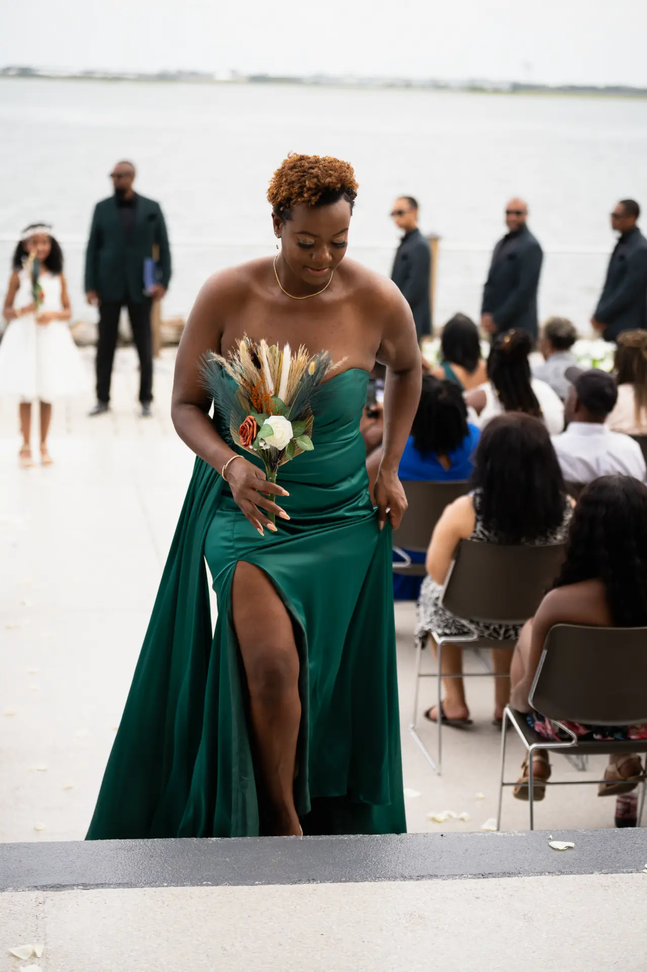 Bridesmaid in an emerald gown walks into the reception