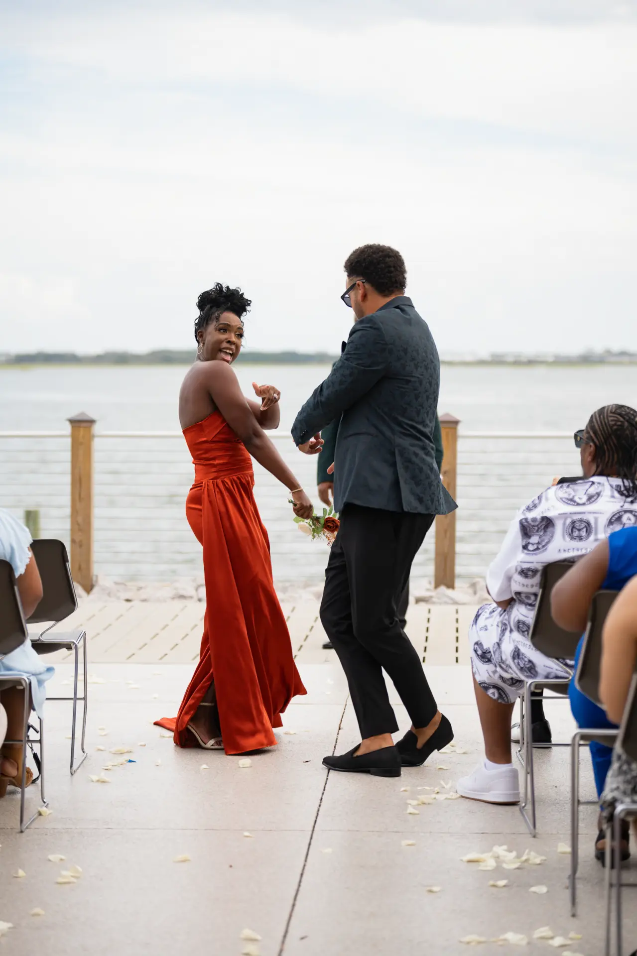 Couple dances on a waterfront deck during the reception