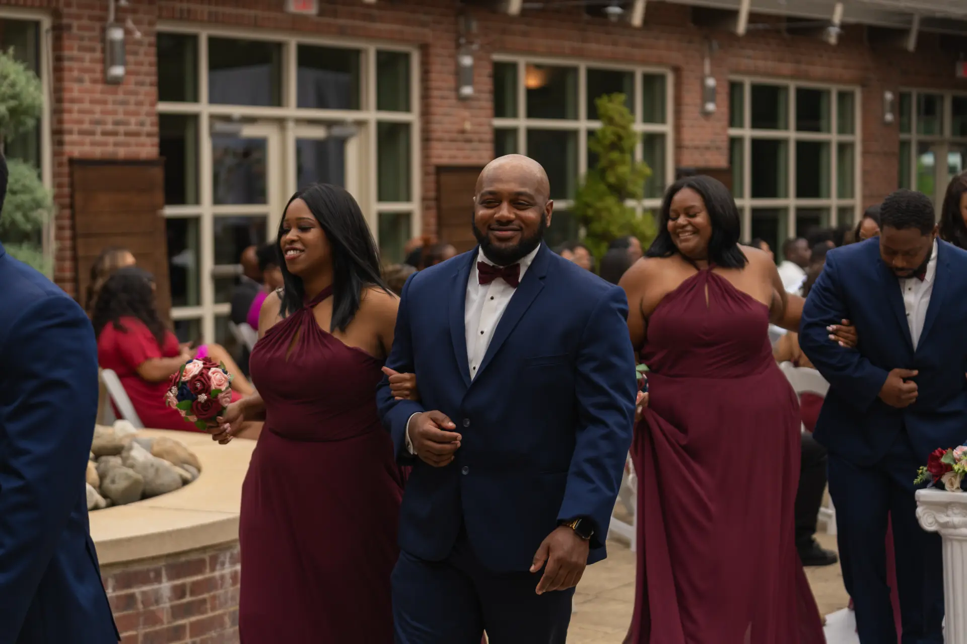 Bridesmaids in burgundy and groomsmen dance at the reception