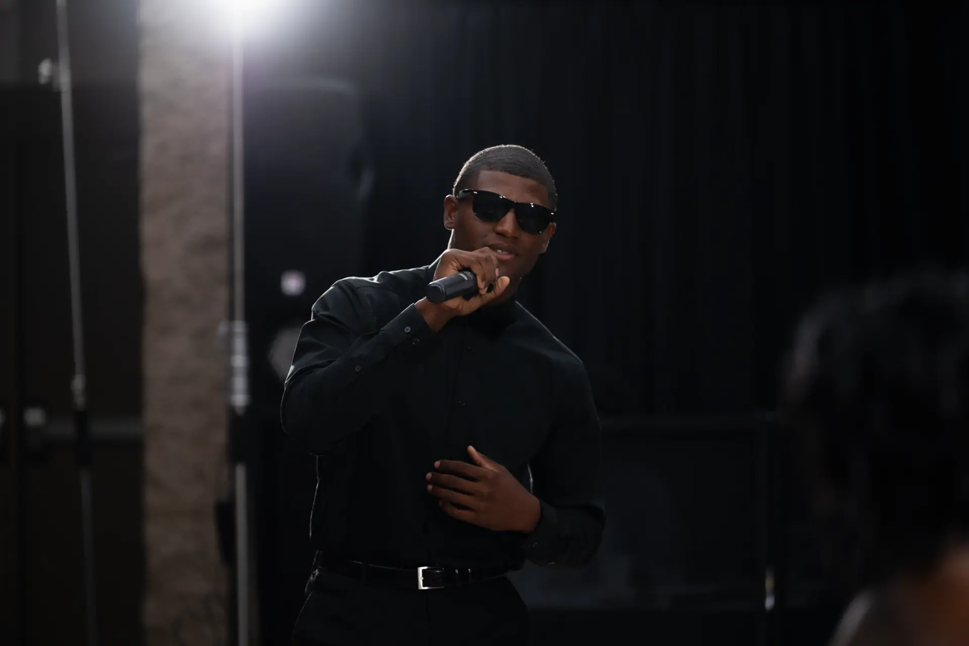 Groomsman in sunglasses dances under stage lights
